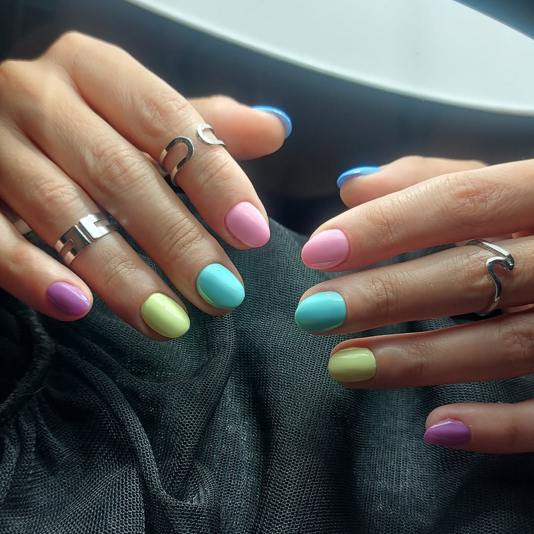 Pastel mavi, yeşil, pembe ve mor tonlarda kısa tırnak uygulaması